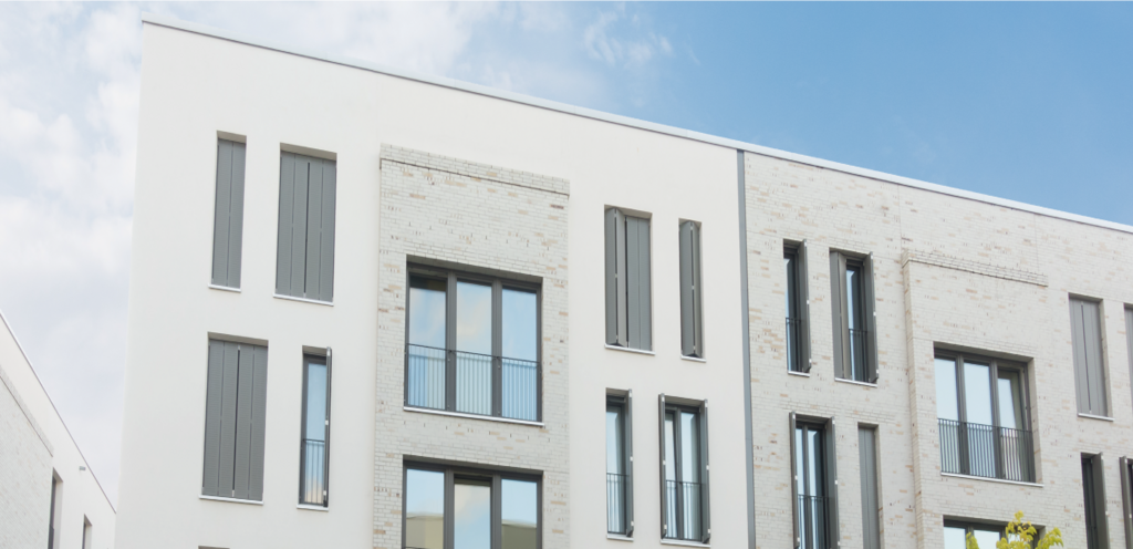 ein Mehrfamilienhaus vor blauem Himmel